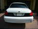 2001 Ford Crown Victoria - The rear of a white Ford Crown Victoria, showing its taillights and Ford emblem.
