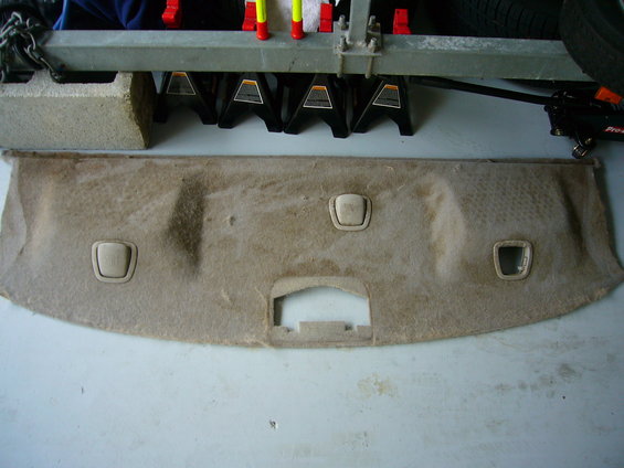 tan car interior trim panel with three light beige plastic clips