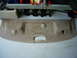 2001 Ford Crown Victoria - A tan car interior trim panel with three light beige plastic clips is laid out on a garage floor.