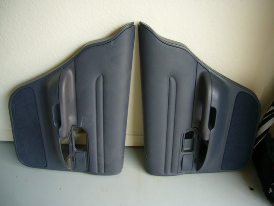 Pair of dark blue car door panels with speaker grilles and interior door handles