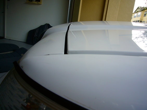 White car hood and roofline with a visible seam between panels