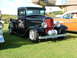 1988 Ford Sport - Black 1930s Ford hot rod pickup truck with custom wheels and "Eighty-Eight Parts" lettering on the door.