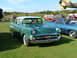 1988 Ford Sport - A classic green and white 1957 Chevrolet sedan is parked on a grassy field next to other vehicles.