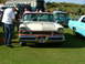 1988 Ford Sport - A man polishes a classic Mercury at an outdoor car show with other vintage vehicles present.