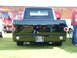 1988 Ford Sport - A black pickup truck is viewed from the rear, parked on grass with other vehicles nearby.