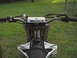 2007 Yamaha YZ450F - Close-up view of motorcycle handlebars and fuel tank with grass in the background.