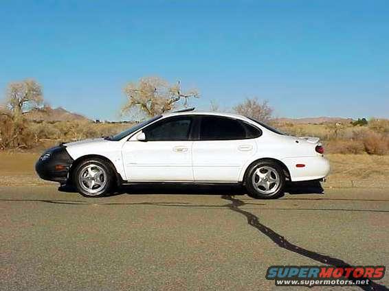 White 1999 Ford Taurus sedan, side view, with black bra on front bumper
