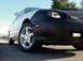 1999 Ford Taurus - A car is parked on a road, its front end covered by a black bra, revealing the headlights and a side marker light.