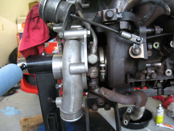 Turbocharger assembly mounted on an engine block, with associated plumbing and linkages