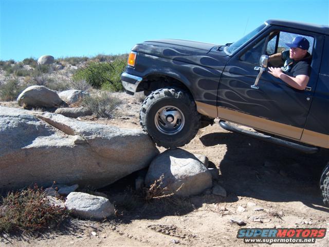 1995 Ford Bronco with flame decals on rocky trail
