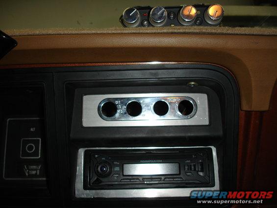 Aftermarket car stereo and four auxiliary switches installed in a dashboard