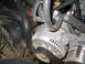 1989 Ford Bronco - Close-up view of an alternator with associated hoses and belts within an engine compartment.