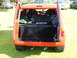 1988 Ford Sport - The rear of an orange hatchback is shown with its hatch open, revealing racing seats and a large subwoofer box.