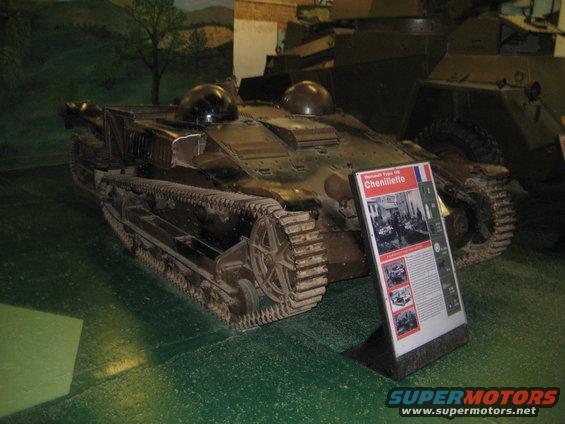 Brown Renault UE Chenillette tank with tracks and two domes on top, displayed with an informational sign