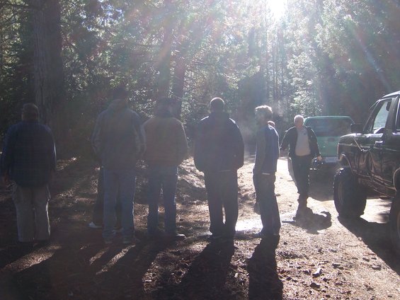 1991 Ford Bronco parked in a forest clearing with several people standing around