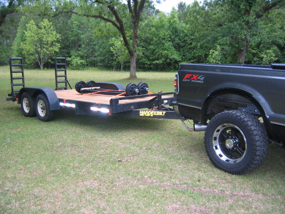 Rear view of black 2005 Ford F-250 towing a car hauler trailer with FX4 Off Road badging