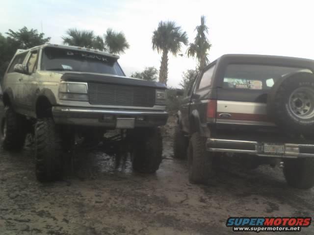 Front view of lifted 1995 Ford Bronco in mud; second Bronco visible