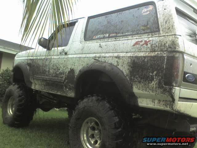 1995 Ford Bronco covered in mud, lifted with large tires