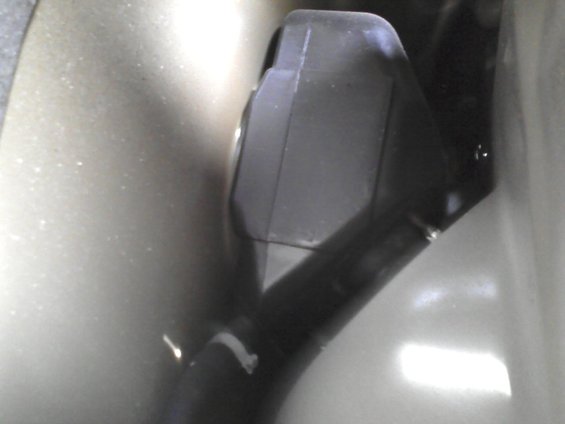 0930071605.jpg The stock NON-remote release fuel filler door opening - as viewed from in the trunk, behind the carpeting - between the fender and trunk bracing