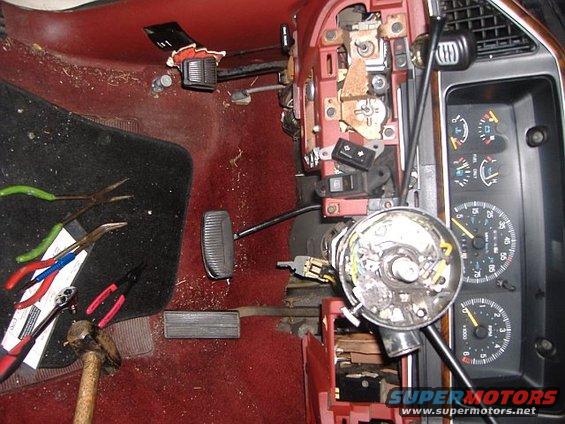1987 Ford Bronco interior showing disassembled dashboard, steering column, pedals, and gauges