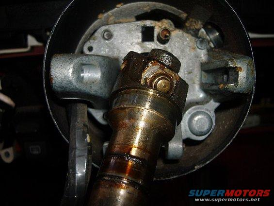 Close-up of a greasy steering column component with metal and grease visible