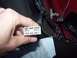 1994 Ford Probe - A hand holds a multi-pin electrical connector near a bundle of wires and a red panel.