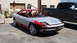 1996 Ford Probe - A sports car in primer and red accents sits next to a pickup truck, awaiting restoration.