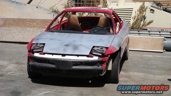 1996 Ford Probe in primer, missing headlights and bumper, red interior visible