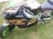 2002 Ford Mustang - A motorcycle with custom flame paint job and bright green rims sits on grass.