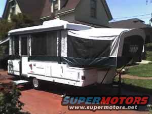White pop-up camper trailer with extended awning
