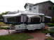 1995 Ford Bronco - This pop-up camper trailer is set up in a residential driveway.