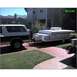 1995 Ford Bronco - A two-tone Ford Bronco is hitched to a pop-up camper in a driveway.