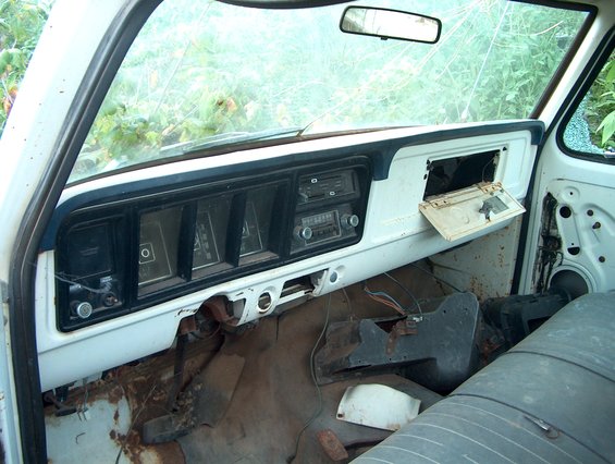 old truck dashboard with cracked windshield and open glove box