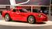 1996 Ford Probe - A red Dodge Viper is displayed at an auto show with other vehicles in the background.