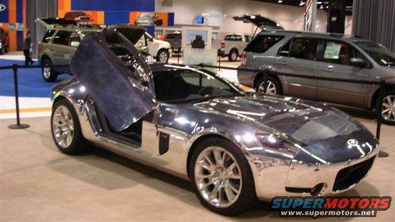Chrome sports car with butterfly doors at an auto show