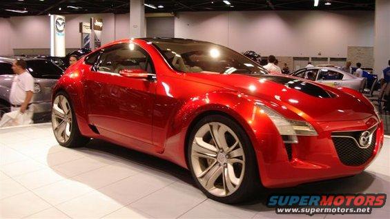 Red concept car with black hood accents and unique headlights on display