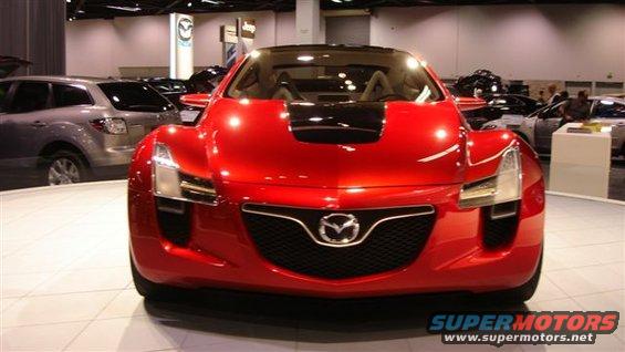 Red concept car with Mazda logo on grille, black hood accent, and visible interior seats