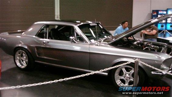 Gray 1967 Ford Mustang coupe with hood open, showing engine