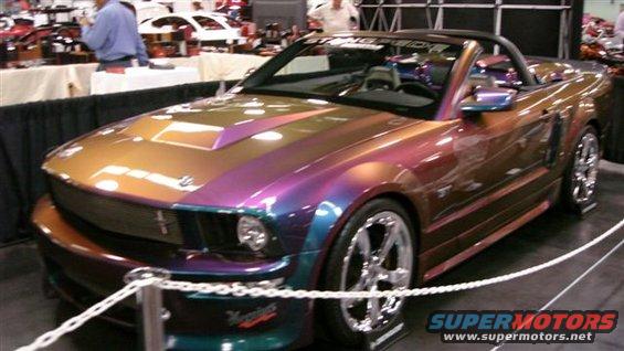 Custom painted Ford Mustang convertible with a hood scoop and chrome wheels
