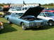 1988 Ford Sport - A light blue 1971 Buick Riviera coupe is displayed with its hood open at an outdoor car show.
