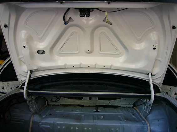 Open white car trunk interior, showing bare metal and wiring, 2001 Ford Crown Victoria