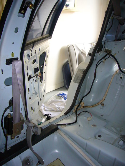 Interior of a 2001 Ford Crown Victoria with door panel removed, showing seatbelt and wiring