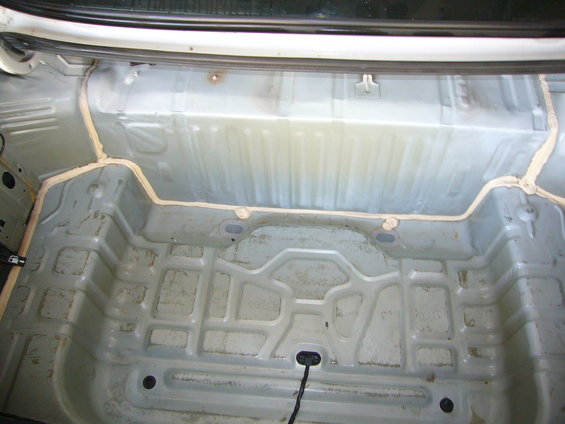 Empty car trunk interior with sealant applied to seams