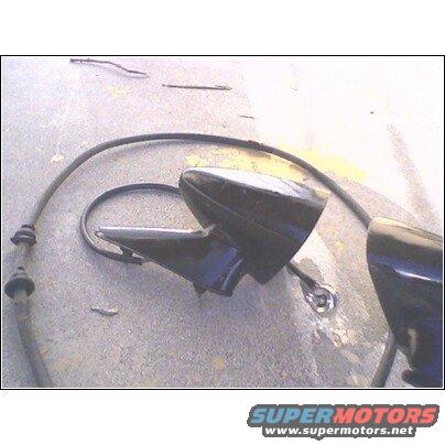 Black side mirror assembly with cable on concrete