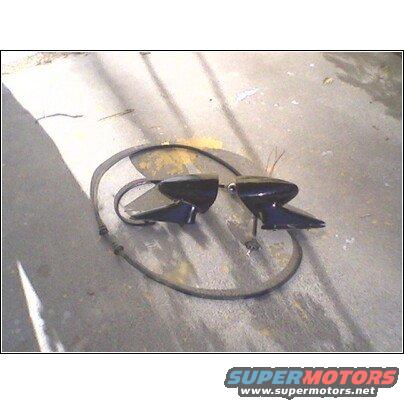 two black side mirrors with wires, lying on concrete