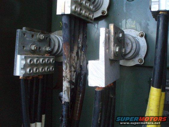 Electrical connections with burnt and frayed cables attached to metal terminals