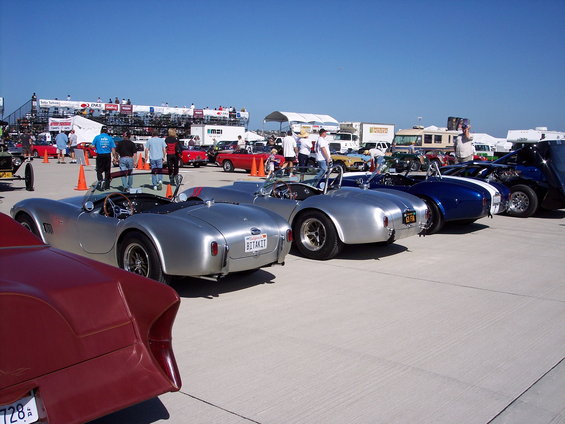 Silver Shelby Cobra replicas parked in a row, one with a license plate reading BOTAKIT