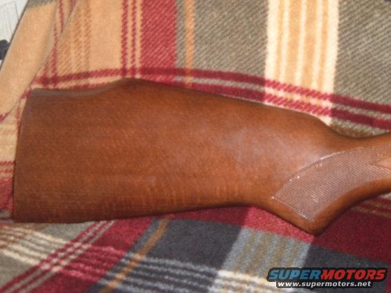 wooden rifle stock on a plaid blanket