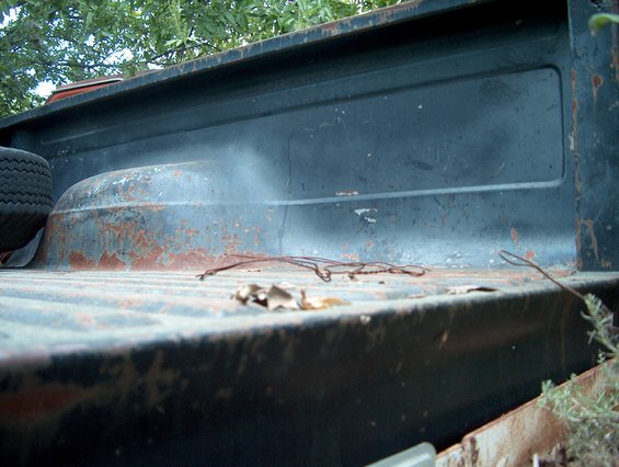 Truck bed interior showing a spare tire on the left and rusty metal. A 1979 Ford Bronco is claimed