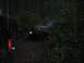 1989 Ford Bronco - Two off-road vehicles navigate a dense forest trail in low light conditions.